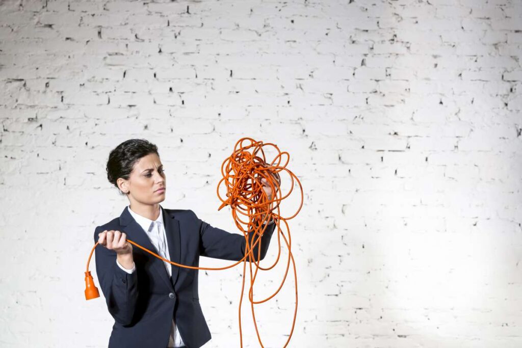 Woman looking at a pile of tangled cables 